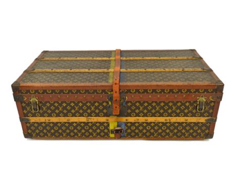 A Louis Vuitton monogram trunk, no.763773, leather bound and with wooden battens, leather side carrying handles, a lift out i