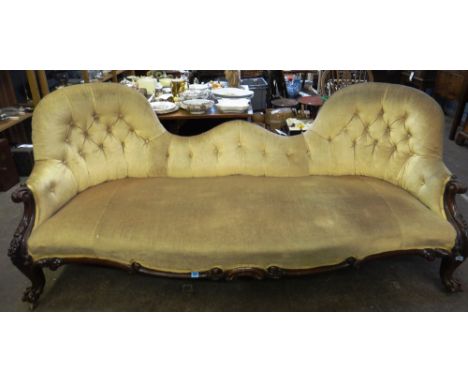 A Victorian carved rosewood frame double spoon back sofa, button down upholstered, on cabriole legs and ball and claw feet, o