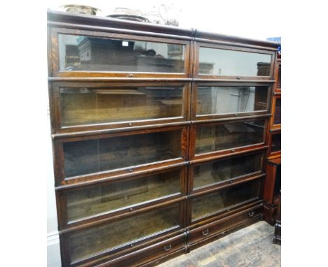 A pair of Globe Wernicke oak five tier bookcases, with glazed up and over doors, drawers below, each 86cm wide. 