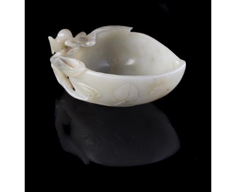 A Chinese pale celadon jade brush washer, Qing Dynasty, with white and black inclusions, carved in the form of a peach with b