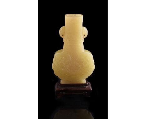 A Chinese yellow jade vase, the flattened body with ruyi-shaped body with tapering neck with elephant handles, the base with 