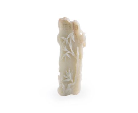 A Chinese celadon jade carving of a tree trunk, carved on one side with pine tree branches and on the reverse side with bambo