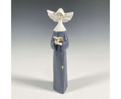 A glossy figure of a Spanish nun reading a book. Lladro backstamp. This item has its original box: 15.5"L x 5.5"W x 4.5"H. Ar
