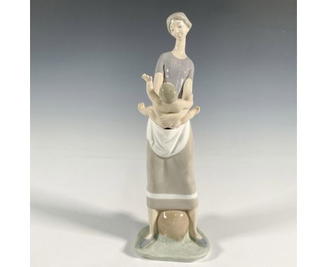 A glossy group figure of a mother holding her child. Lladro backstamp. This item has its original box: 16"L x 7"W x 7.5"H. Ar