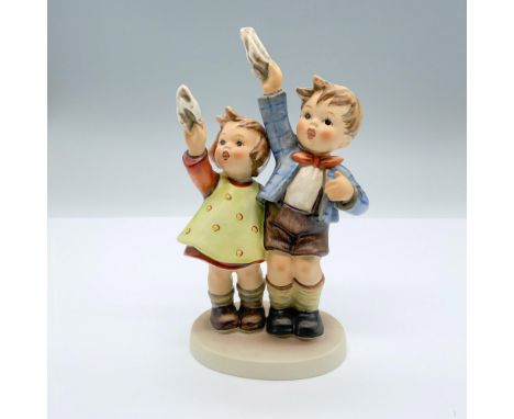 Hand-painted figurine depicting a boy and girl waving handkerchiefs at the sky. Goebel backstamp on the bottom. Dimensions: 3