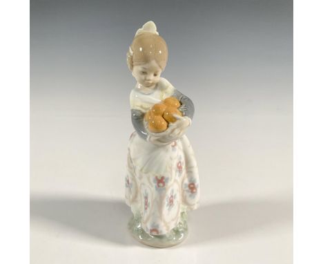 A glossy figure of a young girl in a floral skirt dress, holding a bunch of oranges. Lladro backstamp. This item has its orig