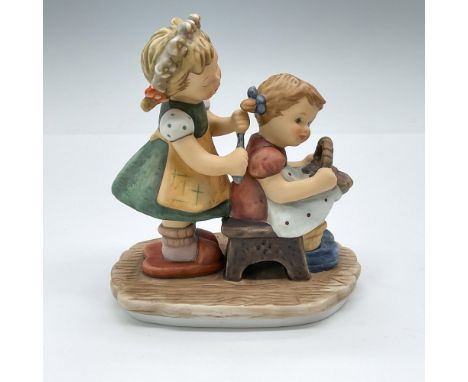 Hand-painted porcelain figurine depicting two girls, one fixing the other one's hair. Marked Berta Hummel to base. Goebel bac