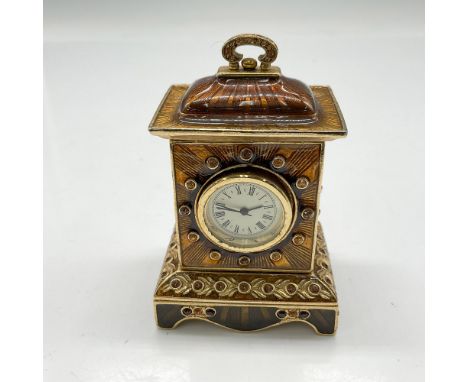 Lovely amber and brown enamel over metal clock housing. Swarovski crystals surround face of clock and around the perimeter of