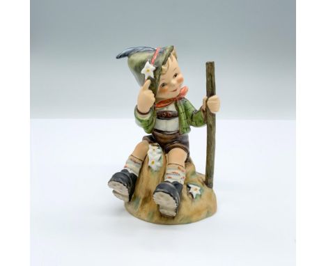 Hand-painted figurine depicting a boy sitting with a walking stick pointing at a flower on his hat. Goebel backstamp on the b