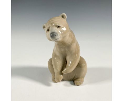 A glossy figure of a seated brown bear with front paws slightly up. Lladro backstamp. This item has its original box: 8"L x 5