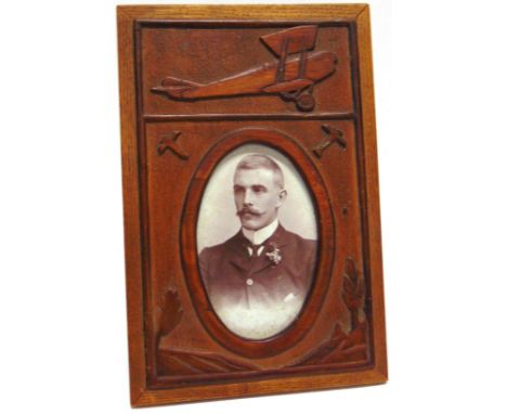 GREAT WAR AVIATION - A CARVED MAHOGANY TRENCH ART PHOTOGRAPH FRAME  decorated in relief with a large profile study of a bipla