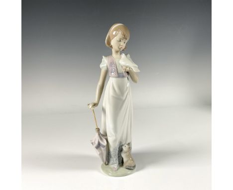 Beautiful glossy porcelain figure capturing a peaceful moment of an adorable girl watching a white dove in her hand and with 