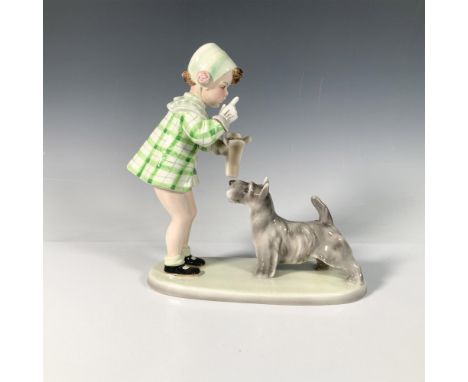 A sweet glossy figure depicting a young girl dress in a lovely green outfit feeding her dog. Goldscheider backstamp. Issued: 