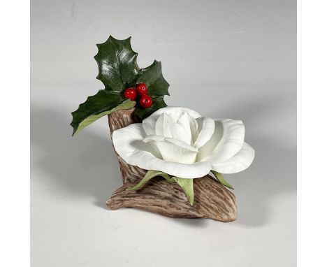 This vintage hand-painted porcelain figurine depicts a white rose in full bloom on a tree branch beneath a sprig of holly wit