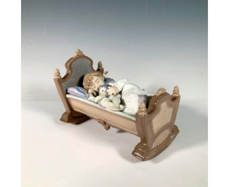 Glossy porcelain figure of a young girl sleeping in a cradle holding her doll. Lladro backstamp. Artist: Francisco PolopeIssu