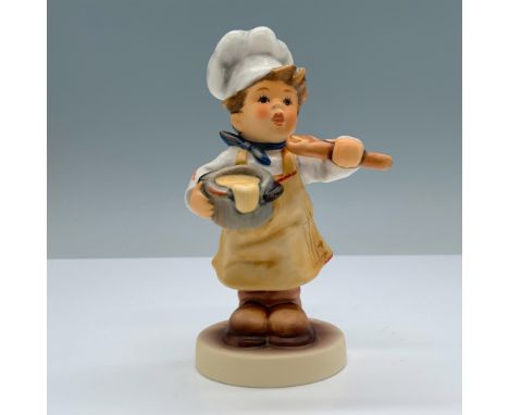 Hand painted porcelain features a young boy dressed as a chef holding a bowl of batter and wooden spoon. Goebel backstamp. M.