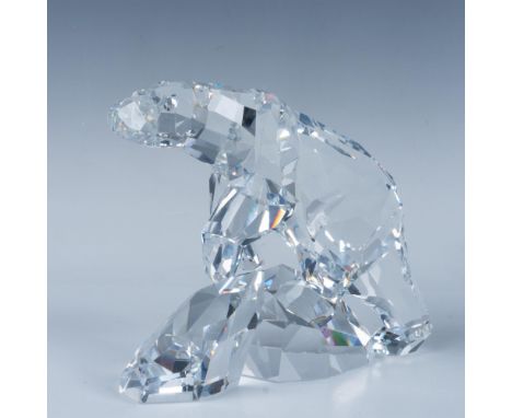 A clear shining crystal figure of a polar bear with many smooth cuts atop of two glaciers. Artist signature. Swarovski swan m