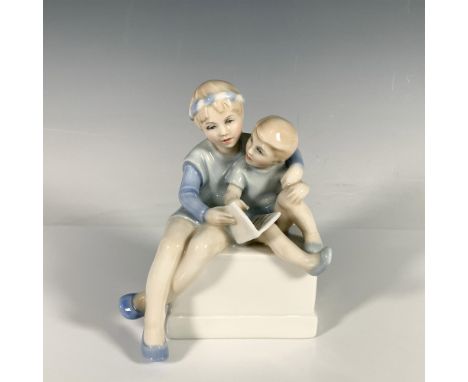 Glossy pastel hued figure of two children reading a book. Part of the Reflections series. Royal Doulton backstamp. Artist: Pa