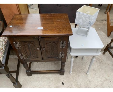 AN OAK JACOBEAN STYLE TWO DOOR CUPBOARD ON OPEN BASE, 20" WIDE, BEDSIDE TABLE AND LAMP 