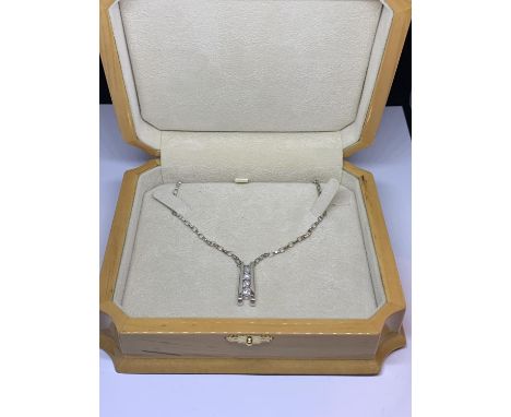 AN 18 CARAT WHITE GOLD NECKLACE WITH A PENDANT INCORPORATING FOUR DIAMONDS WITH A 50CM CHAIN IN A WOODEN PRESENTATION BOX 