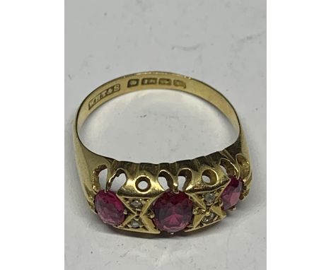 A 9 CARAT GOLD RING WITH THREE IN LINE RUBYS AND FOUR DIAMONDS SIZE P 
