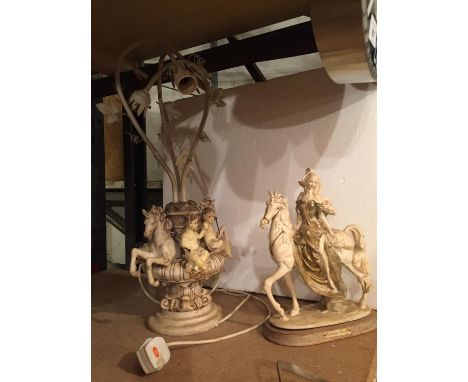 A RESIN MODEL OF A LADY ON A HORSE AND AN ORNATE TABLE LAMP DECORATED WITH CHERUBS AND HORSES 