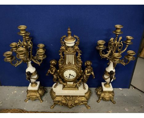 AN ORNATE IMPERIAL FRENCH GILT MANTLE CLOCK ON A MARBLE AND GILT BASE WITH CHERUB FAWN DECORATION AND SEVEN BRANCH CANDLESTIC