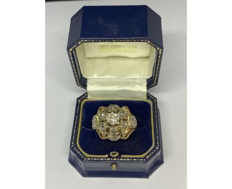 AN 18 CARAT WHITE AND YELLOW GOLD ART DECO CLUSTER RING WITH A CENTRE DIAMOND, SIX SURROUNDING DIAMONDS, FOURTEEN SHOULDER DI