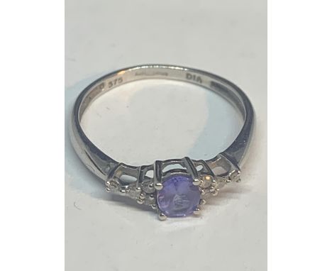 A 9 CARAT WHITE GOLD RING WITH A SINGLE AMETHYST SURROUNDED BY DIAMONDS SIZE L/M IN A PRESENTATION BOX 