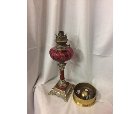 AN OIL LAMP WITH CRANBERRY GLASS, AN ARTILLIARY SHELL BASE AND A PEN KNIFE 