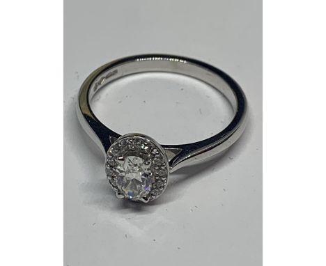 A PLATINUM AND DIAMOND OVAL HALO RING SIZE N/O IN A PRESENTATION BOX 