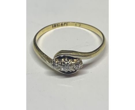 AN 18CT CARAT GOLD RING ON A CROSS OVER DESIGN WITH THREE IN LINE DIAMONDS WITH A PRESENTATION BOX 