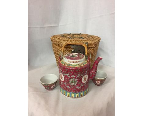 AN ORIENTAL STYLE TEAPOT AND TEA BOWLS COMPLETE WITH A CARRYING BASKET 