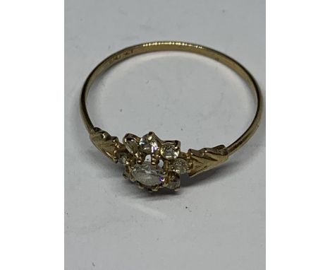 A 9 CARAT GOLD RING SUPPORTING A NINE CLEAR STONE FLOWER DESIGN WITH ARROW DESIGN SHOULDER SIZE O IN A PRESENTATION BOX 