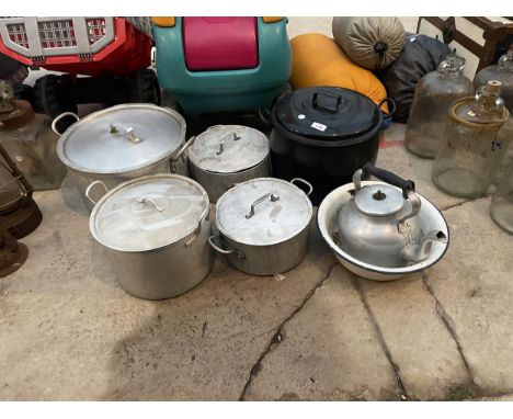 A GROUP OF FOUR LARGE STAINLESS STEEL COOKING POTS WITH LIDS, A LARGE BLACK ENAMEL COOKING POT WITH LID AND AN ENAMEL WASH BO