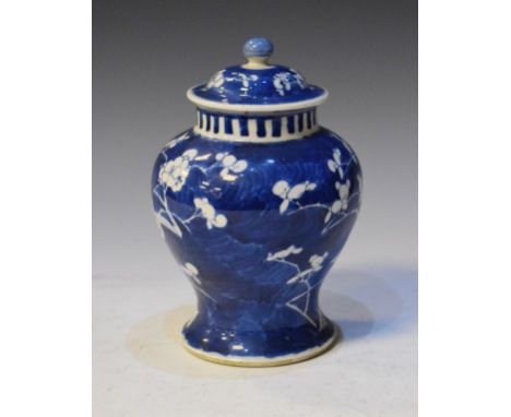 Chinese porcelain baluster shaped jar and cover decorated with prunus blossom on a blue ground, the underside with Kangxi fou