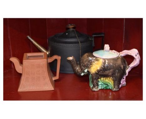 Early 19th Century black basalt oval teapot having an unmarked white metal spout, late 19th Century majolica teapot formed as