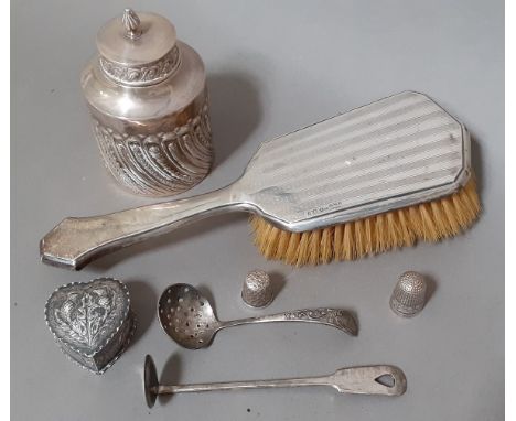 A selection of silver items including a tea caddy, small heart shaped pill box, pusher, two thimbles, a brush and an EPNS str