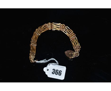 A yellow metal gate link bracelet, the heart-shaped locket clasp stamped '9c.'.