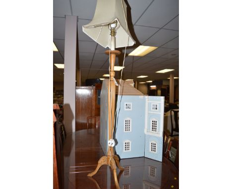 A modern stained wood standard lamp with cream coloured shade.