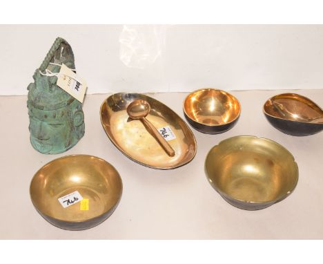 A brass/bronze Asian cast head; together with five brass dishes and matching spoon.