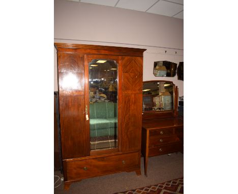 An Edwardian inlaid mahogany wardrobe with mirror panel door; together with matching dressing chest; and bed ends only.