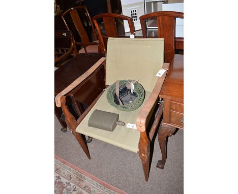 Folding military campaign chair made from turned teak, leather and canvas; together with an American army tin helmet and felt