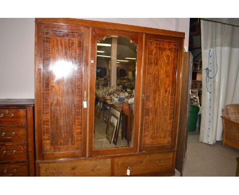 An Edwardian inlaid mahogany wardrobe, with central mirror panel door, 71 x 77in. high.