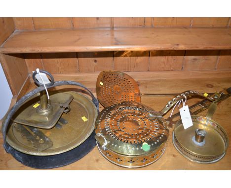 An antique brass chestnut roaster, with pierced decoration; a brass skimmer; and a brass chamber candlestick.