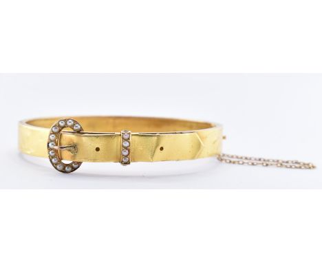 A 19th century yellow metal and pearl buckle bracelet bangle. The bangle having a half pearl buckle motif with hidden box fas