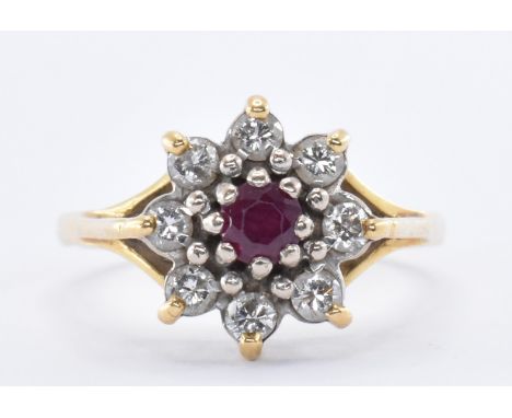 A 18ct gold ruby and diamond cluster ring having a central round cut ruby with surrounded by eight round cut diamonds. Marked