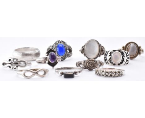 A collection of silver rings to include a mother of pearl set ring, an agate cabochon ring, a blue stone and marcasite set ri