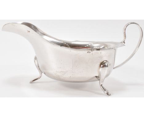 A 1930's Art Deco era Viner's silver hallmarked gravy boat / creamer jug having a shaped rim with cabriole legs. Hallmarked S
