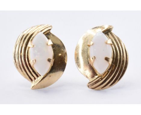 A pair of 14ct gold stud earrings set with marquise shaped opal cabochons to each. Marked 585 to the posts. Weight 0.49g. Hea